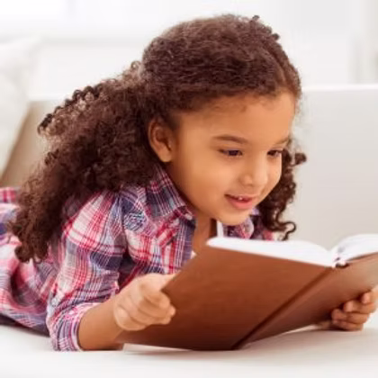 A young girl reading a book making the child smarter